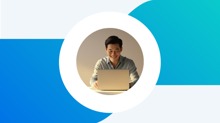 A smiling man working on a laptop
